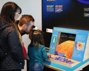 Family interacting with Sun Earth Universe exhibit